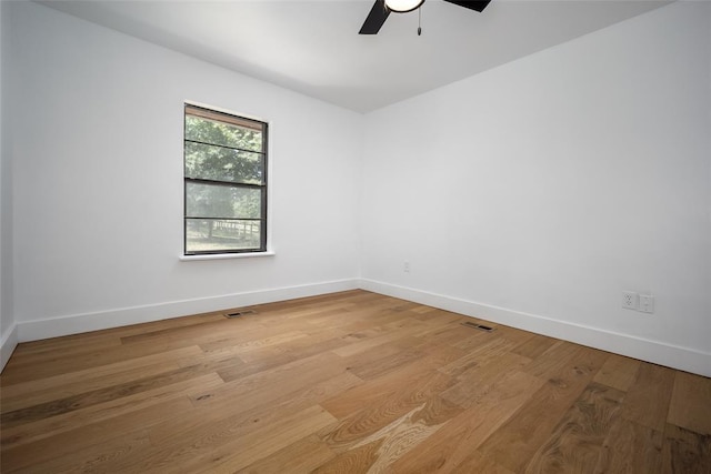 spare room featuring baseboards, a ceiling fan, and light wood finished floors