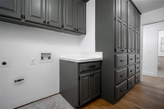 laundry area with light wood-type flooring, hookup for an electric dryer, cabinet space, and washer hookup