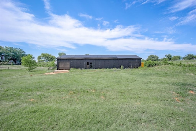 exterior space featuring a pole building, fence, an outbuilding, and a rural view