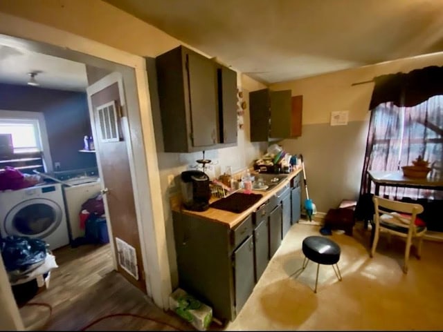 kitchen featuring washer / clothes dryer, dark wood-style flooring, visible vents, and light countertops