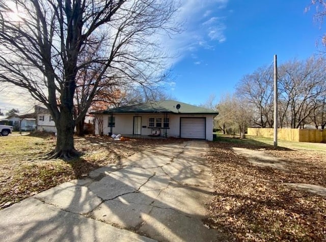 view of front facade featuring a garage, fence, covered porch, and concrete driveway