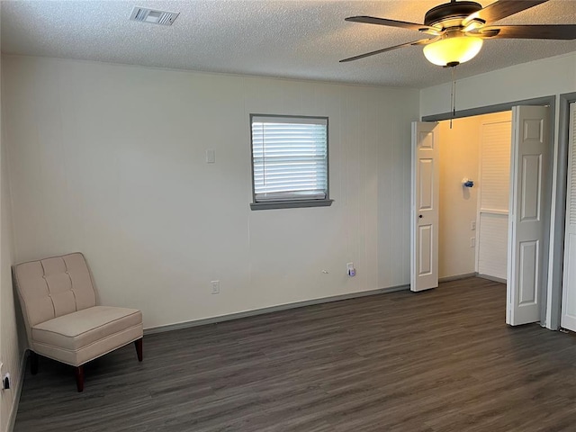 3233 SW 40th St, Oklahoma City, OK 73119 - unfurnished bedroom featuring visible vents, baseboards, dark wood-style floors, a textured ceiling, and a ceiling fan