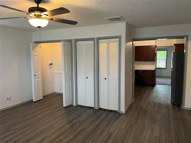 3233 SW 40th St, Oklahoma City, OK 73119 - unfurnished bedroom featuring dark wood-type flooring, freestanding refrigerator, a textured ceiling, and visible vents