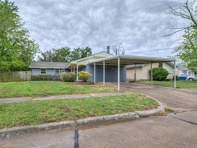 ranch-style home with brick siding, fence, driveway, and a front lawn