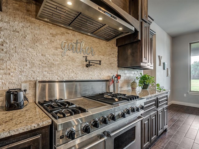 7437 SW 105th St, Oklahoma City, OK 73173 - kitchen with backsplash, dark brown cabinetry, wall chimney range hood, and range with two ovens