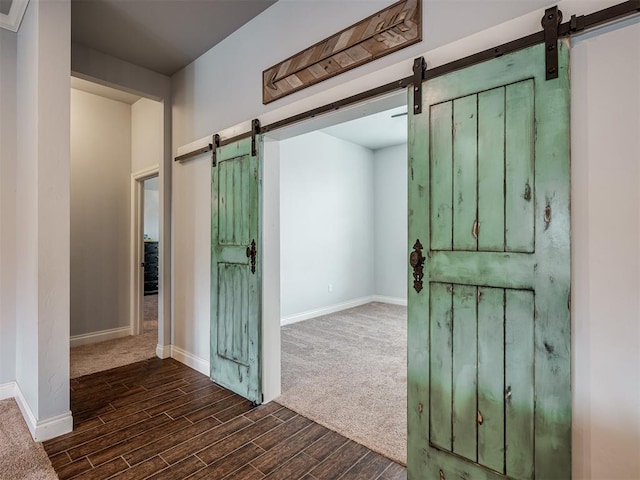 7437 SW 105th St, Oklahoma City, OK 73173 - hall with baseboards, a barn door, and wood finished floors