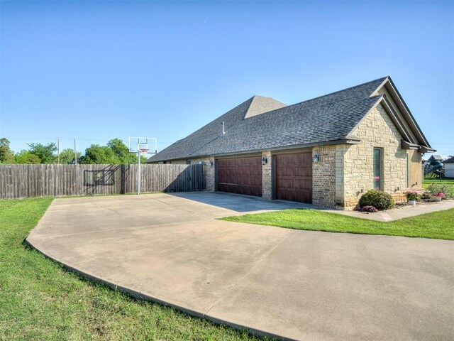 7437 SW 105th St, Oklahoma City, OK 73173 - view of home's exterior with driveway, roof with shingles, a garage, fence, and stone siding