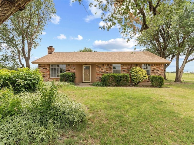ranch-style house featuring a chimney, a front lawn, and brick siding