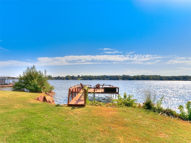 dock area with a lawn and a water view