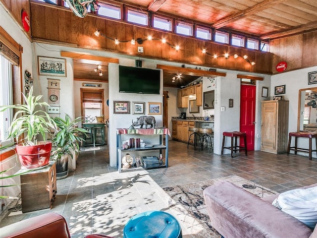 living room featuring a towering ceiling and wooden ceiling