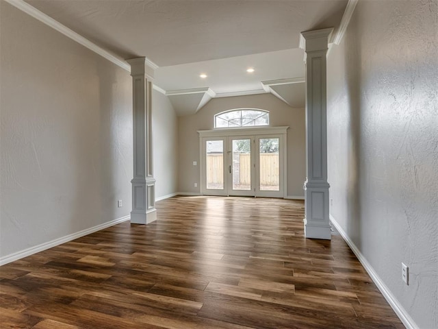 interior space featuring ornate columns, baseboards, vaulted ceiling, and dark wood-style floors