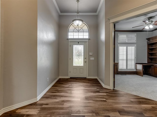 entrance foyer featuring crown molding, a ceiling fan, baseboards, and dark wood-type flooring