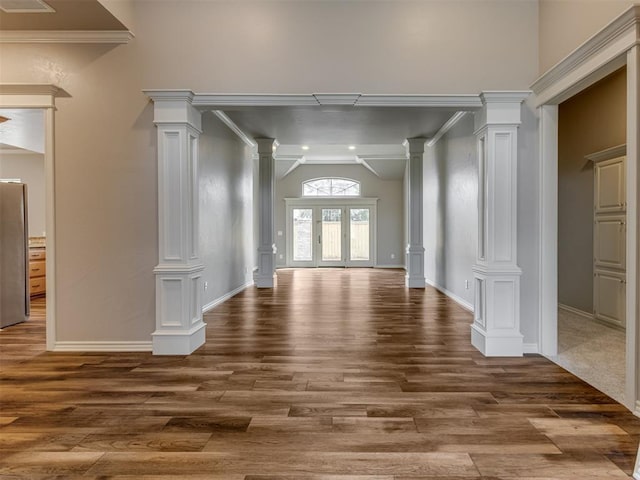 interior space featuring baseboards, decorative columns, dark wood-style floors, and lofted ceiling