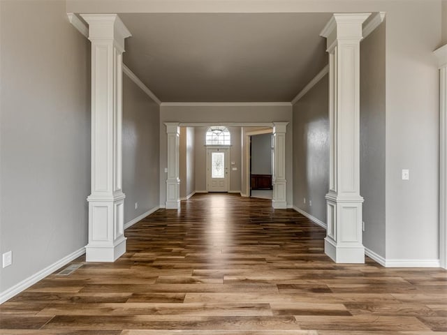 foyer entrance with baseboards, crown molding, and wood finished floors