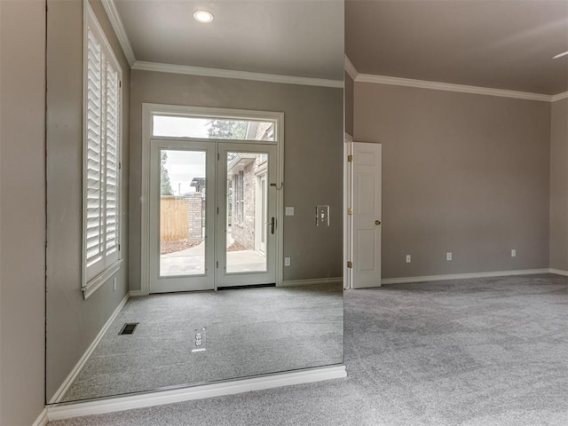 carpeted foyer with crown molding, baseboards, visible vents, and french doors