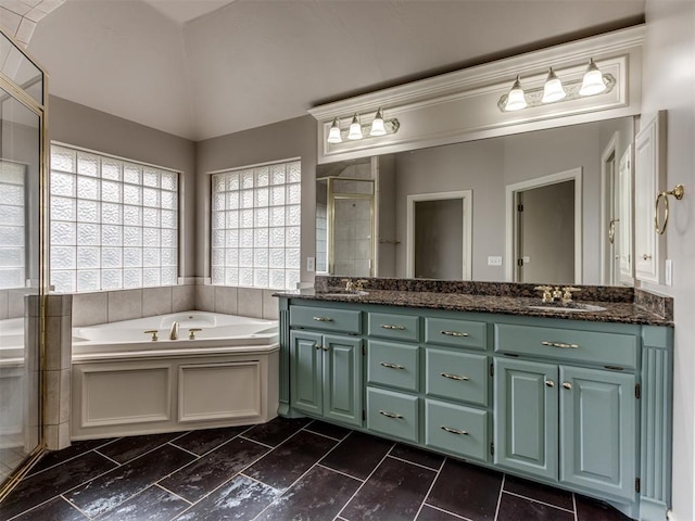 full bathroom with double vanity, a sink, a bath, and a stall shower