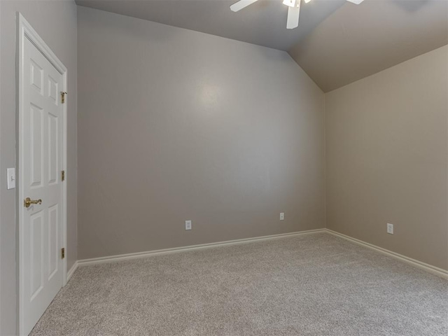 empty room with carpet floors, a ceiling fan, baseboards, and lofted ceiling