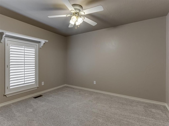 spare room with baseboards, ceiling fan, carpet flooring, and visible vents