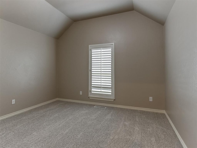 additional living space featuring carpet flooring, baseboards, visible vents, and vaulted ceiling