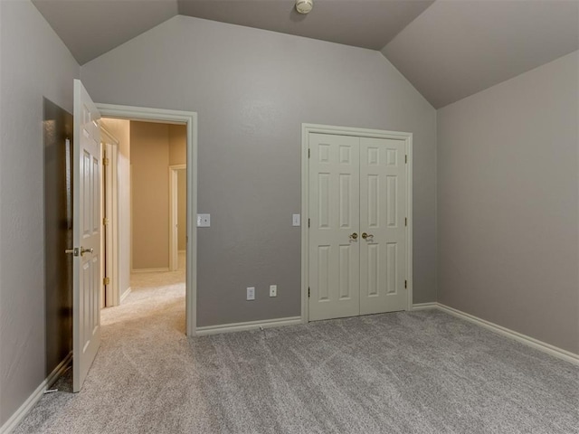 unfurnished bedroom with vaulted ceiling, carpet, and a closet