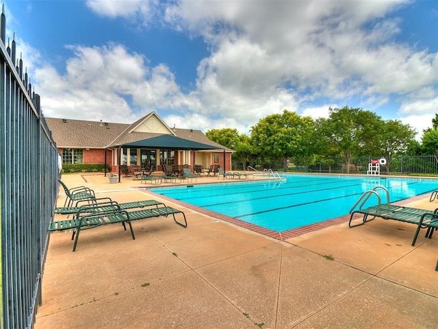 pool with fence and a patio