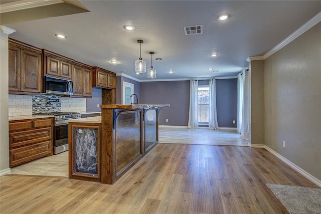 kitchen featuring baseboards, ornamental molding, stainless steel appliances, and visible vents