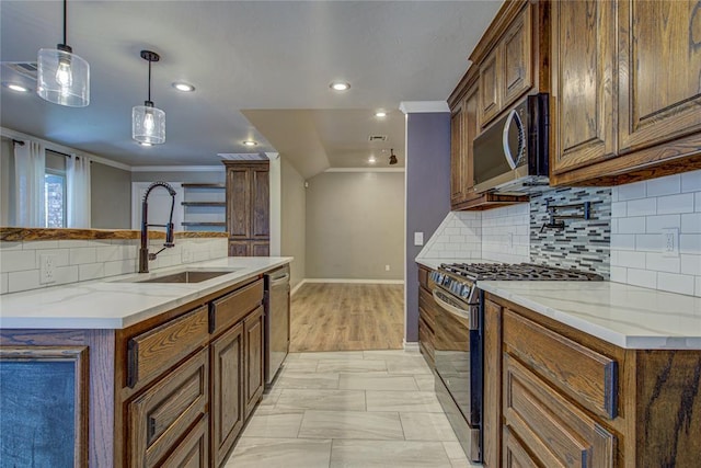 kitchen featuring a sink, appliances with stainless steel finishes, backsplash, and ornamental molding