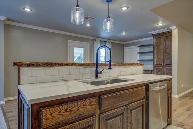 kitchen featuring stainless steel dishwasher, visible vents, a sink, and light wood-style flooring