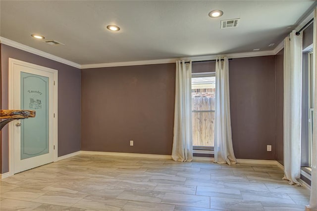 spare room featuring baseboards, visible vents, and ornamental molding