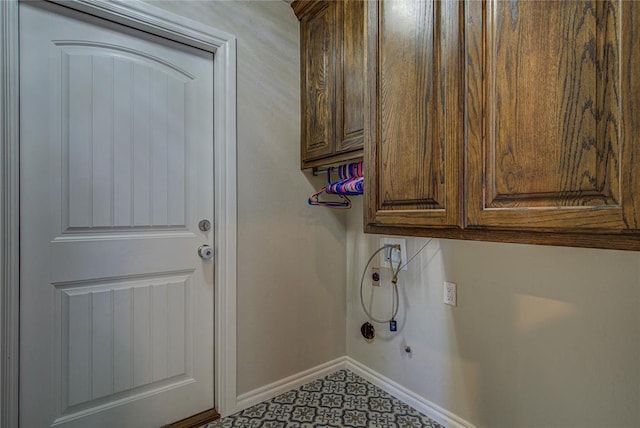 washroom with baseboards, hookup for a washing machine, and cabinet space