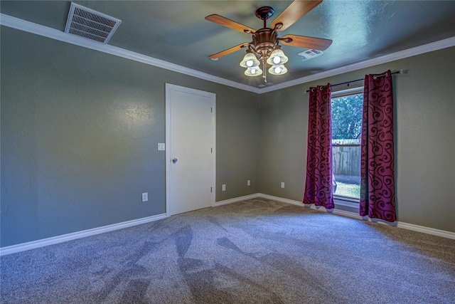 spare room with ceiling fan, carpet floors, baseboards, visible vents, and ornamental molding