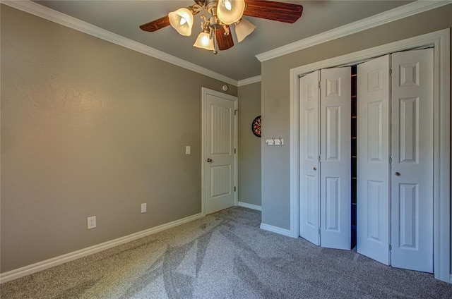 unfurnished bedroom featuring a ceiling fan, baseboards, a closet, ornamental molding, and carpet flooring