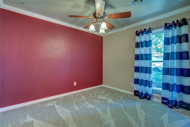 spare room with ceiling fan, carpet floors, baseboards, visible vents, and ornamental molding