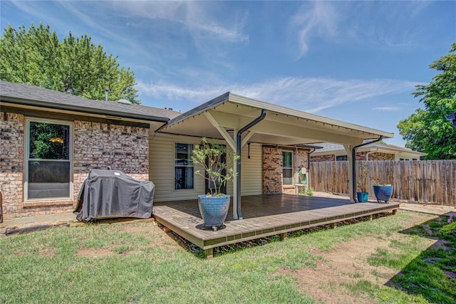 back of house featuring a lawn, fence, and a wooden deck