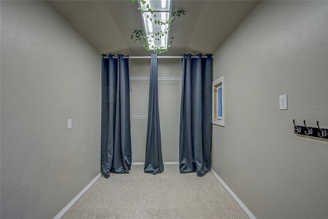unfurnished room with baseboards, carpet, and lofted ceiling