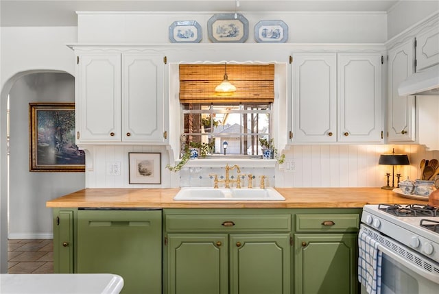 kitchen featuring stainless steel dishwasher, white cabinetry, butcher block counters, and a sink