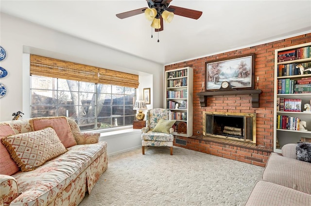 carpeted living area featuring a ceiling fan, built in shelves, a wealth of natural light, and a fireplace