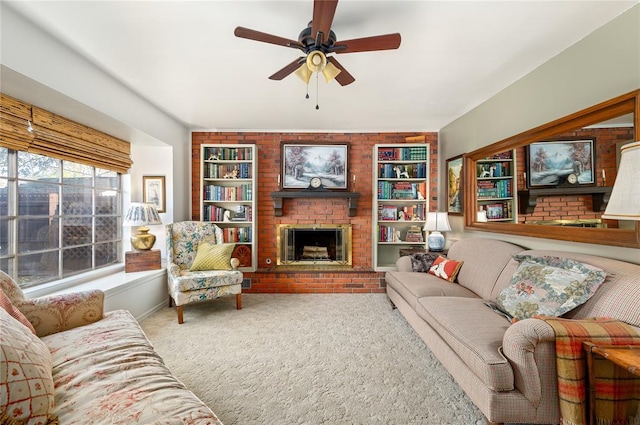 living room featuring a ceiling fan, carpet, a fireplace, and built in shelves