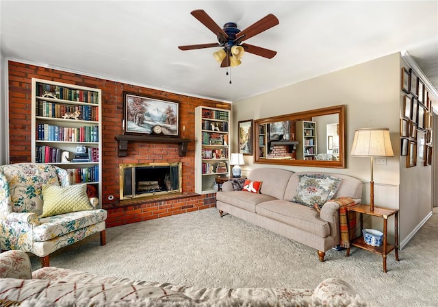carpeted living room with built in shelves, baseboards, a ceiling fan, and a brick fireplace