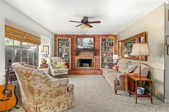 carpeted living area with a ceiling fan, a brick fireplace, and built in shelves