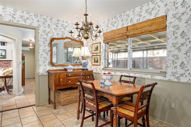 dining room featuring an inviting chandelier, a wainscoted wall, and wallpapered walls