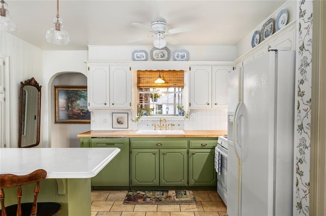 kitchen with a ceiling fan, white appliances, green cabinetry, white cabinets, and a sink