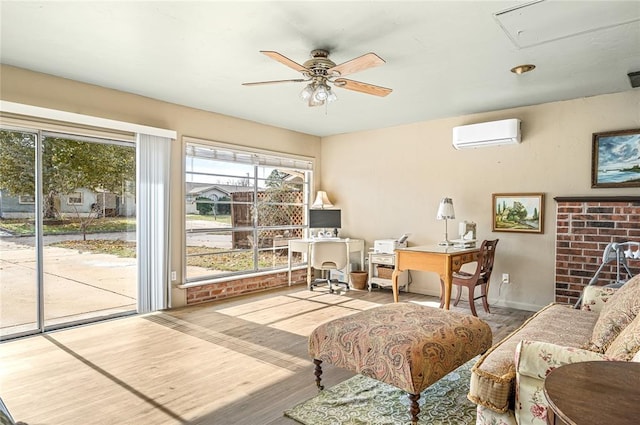 living room with a ceiling fan, attic access, wood finished floors, and an AC wall unit