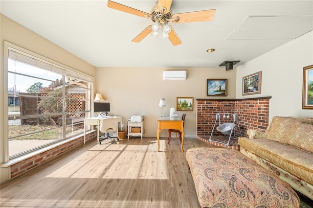 living area with an AC wall unit, a ceiling fan, and wood finished floors