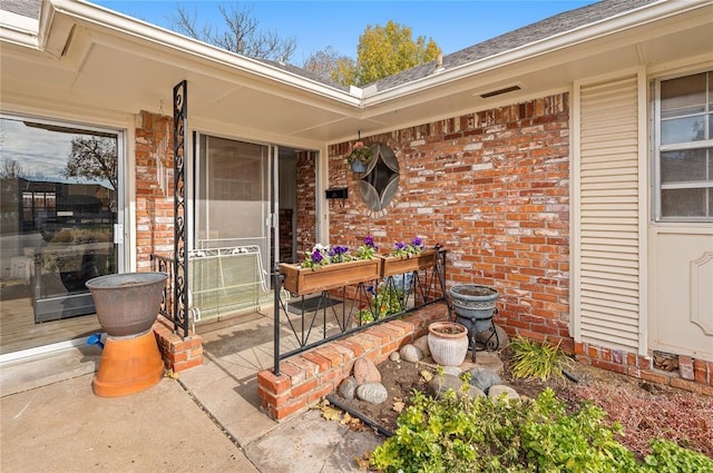 doorway to property featuring brick siding