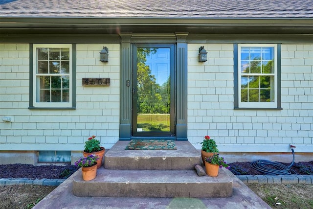 entrance to property with roof with shingles