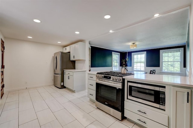 kitchen featuring light countertops, stainless steel appliances, recessed lighting, and white cabinetry
