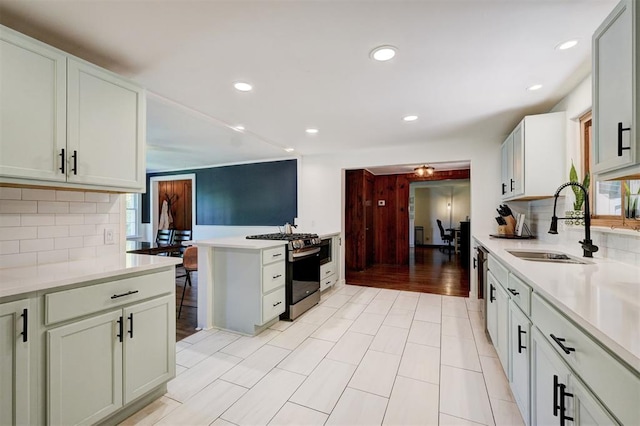 kitchen featuring light countertops, a sink, backsplash, and stainless steel appliances