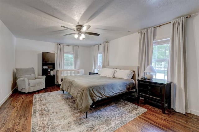 bedroom with ceiling fan, wood finished floors, and multiple windows
