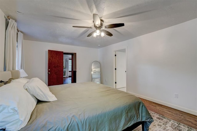 bedroom with baseboards, a ceiling fan, and wood finished floors